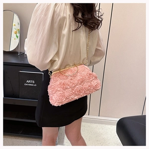 Detail of pink floral evening clutch with 3D fabric roses and golden metal ring handle