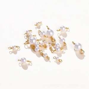 Macro shot of 18K gold-plated copper wire-wrapped pearl pendants for DIY jewelry making