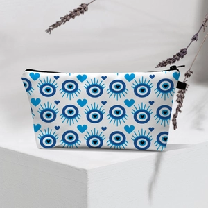 Detail of waterproof evil eye makeup bag with heart pattern on a white pedestal