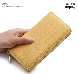 Close-up of yellow pebbled leather wallet featuring a durable silver metal zipper detail