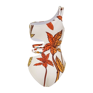 Detail of one-shoulder swimsuit featuring orange leaf print and colorful waist beads