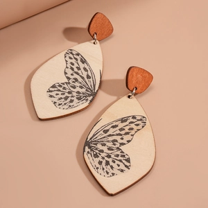 Detailed view of wooden teardrop earrings featuring vintage butterfly wing print patterns