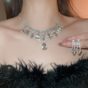 Detailed close-up of crystal water drop pendant necklace and matching tassel earrings