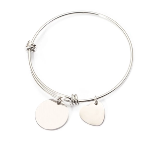 Macro detail of silver adjustable stainless steel bangle with round and heart charms