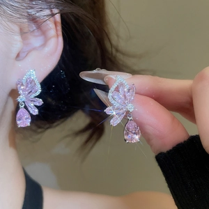Detailed view of elegant pink butterfly earrings with teardrop zircon drop on model