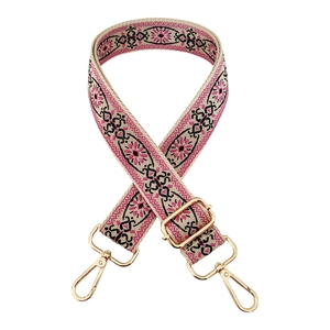 Close-up of pink geometric ethnic style woven canvas bag strap with gold metal hardware