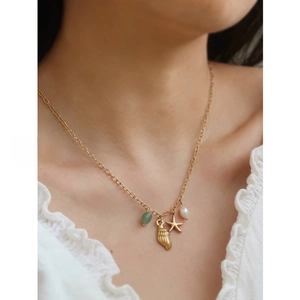 Detailed close-up of ocean series necklace with starfish, conch, pearl and green jade pendant