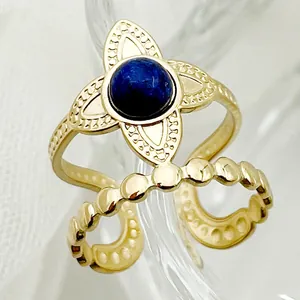 Macro shot of gold double-layer open ring with blue stone and floral filigree details