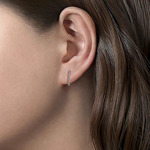 Minimalistische zilveren oorbellen met kleine diamanten pavé-zetting op de oorlel