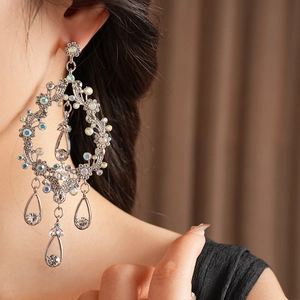 Detailed close-up of intricate hollow waterdrop tassel earrings with shimmering crystals