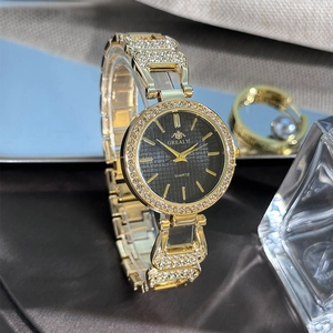 Détail de montre luxe pour femme avec lunette en strass et cadran noir texturé