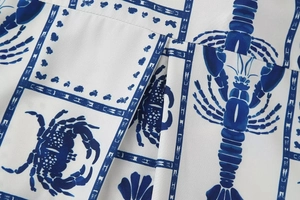 Detailed macro view of white fabric with blue lobster and crab ocean patterns