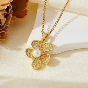 Détail du collier pendentif fleur dorée avec perle blanche et pavé de micro-zircons