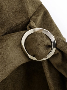 Detail view of olive green faux suede dress featuring a decorative round metal buckle