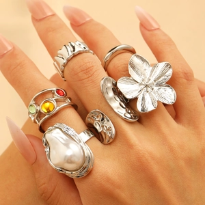 Baroque rings set with pearls, floral motifs, and colored stones on model fingers