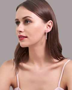 Close-up of long silver linear tassel earrings with sparkling crystals on a model