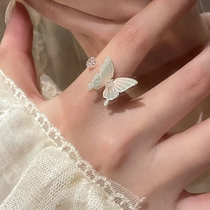 Macro detail of silver butterfly ring with pearlescent wings and sparkling rhinestones