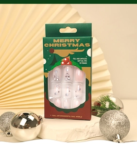Detail of Christmas press-on nails with silver rhinestone tree in green festive packaging