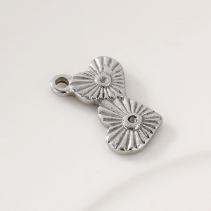 Détail macro du pendentif double cœur argenté avec texture radiale et anneau