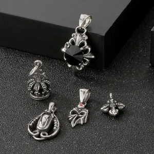 Detailed shot of five vintage stainless steel pendants including crown and cross designs