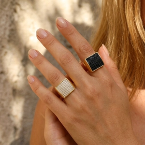 Close-up of hip hop square signet rings with pave-set black and white crystals