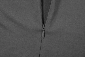 Macro shot of charcoal grey garment showing a seamless invisible zipper detail
