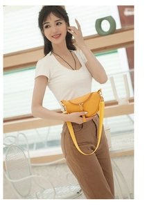 Close-up of vibrant yellow croc-effect crescent saddle bag with gold-tone hardware detail