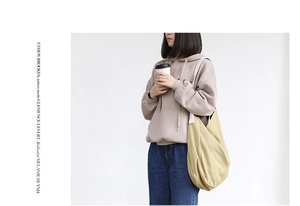 Detail of minimalist beige canvas tote bag showing thick texture and spacious interior