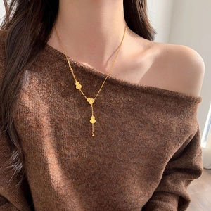 Close-up of 18k gold plated necklace featuring three cascading gourd pendants on a model