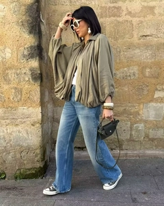 Vue street style d'une chemise vert olive à manches chauve-souris et d'un jean bleu avec accessoires