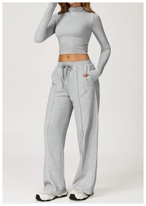 Detail of grey high-waisted wide-leg sweatpants with drawstring and front seam lines