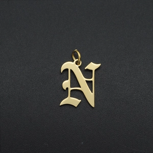 Detailed view of an Old English letter N charm in gold-plated stainless steel