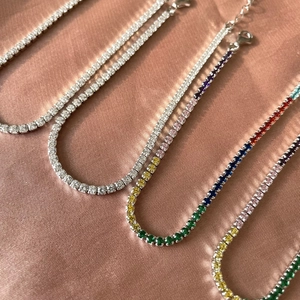 Detail of four S925 sterling silver tennis bracelets with zircon on pink silk backdrop