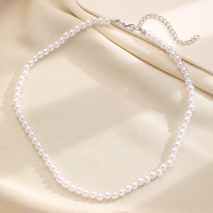 Close-up detail of a classic white imitation pearl choker necklace with silver metal clasp.