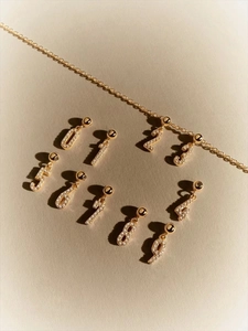 Detailed view of gold S925 silver number pendants set with sparkling zircon stones