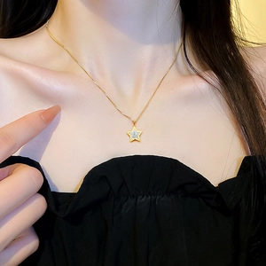 Minimalist gold star pendant necklace with cubic zirconia on a female model