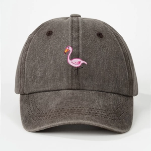Close-up of pink flamingo embroidery and washed cotton texture on dark grey baseball cap