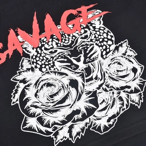 Gros plan du texte savage et du graphique léopard rose sur un t-shirt noir à manches courtes