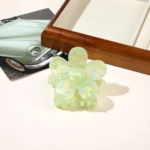 Close-up of light green pearlescent flower hair claw clip with iridescent finish