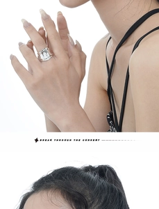 Close-up of a wide minimalist silver ring with unique origami-style texture on a finger