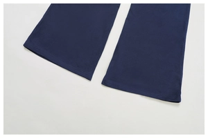 Detail of double-needle stitching on the wide-leg cuffs of navy blue sports trousers
