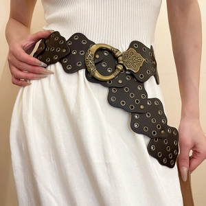 Close-up of vintage brown waist chain with round rivets and baroque buckle