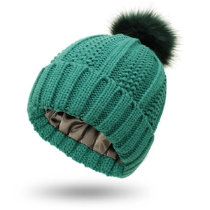 Detailed view of dark green knit beanie with soft silk lining to protect hair textures