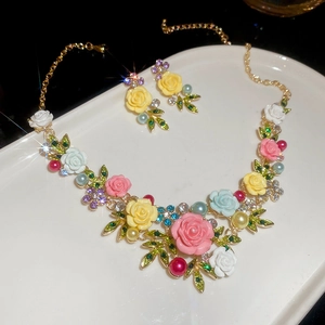Detail of floral jewelry set with colorful resin roses, pearls and sparkling rhinestones