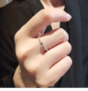 Close-up of silver ring with rectangle center stone and pavé band on model