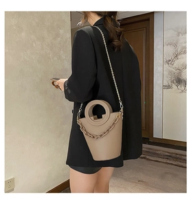 Detail view of khaki PU bucket bag with ring handle and decorative thick chain strap