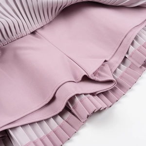 Détail de l'ourlet de la mini-jupe plissée rose avec short intérieur pour femme