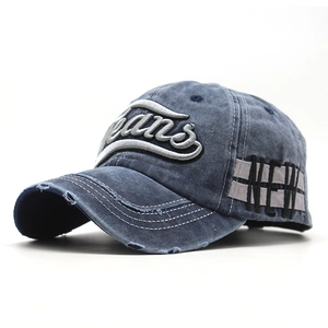 Detail of vintage washed denim baseball cap featuring white Jeans embroidery and frayed edges