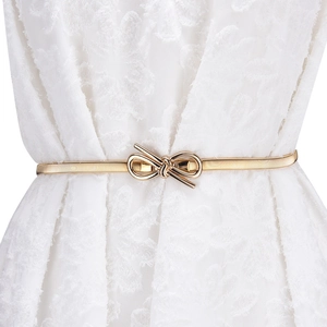 Elegant gold metal elastic waist belt with bow buckle on a white lace dress