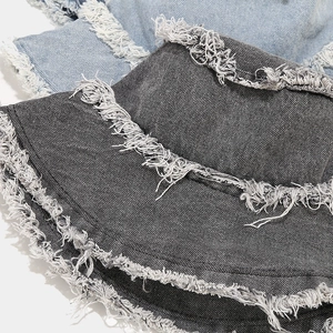 Detail of frayed edges on vintage washed denim bucket hats in black and light blue